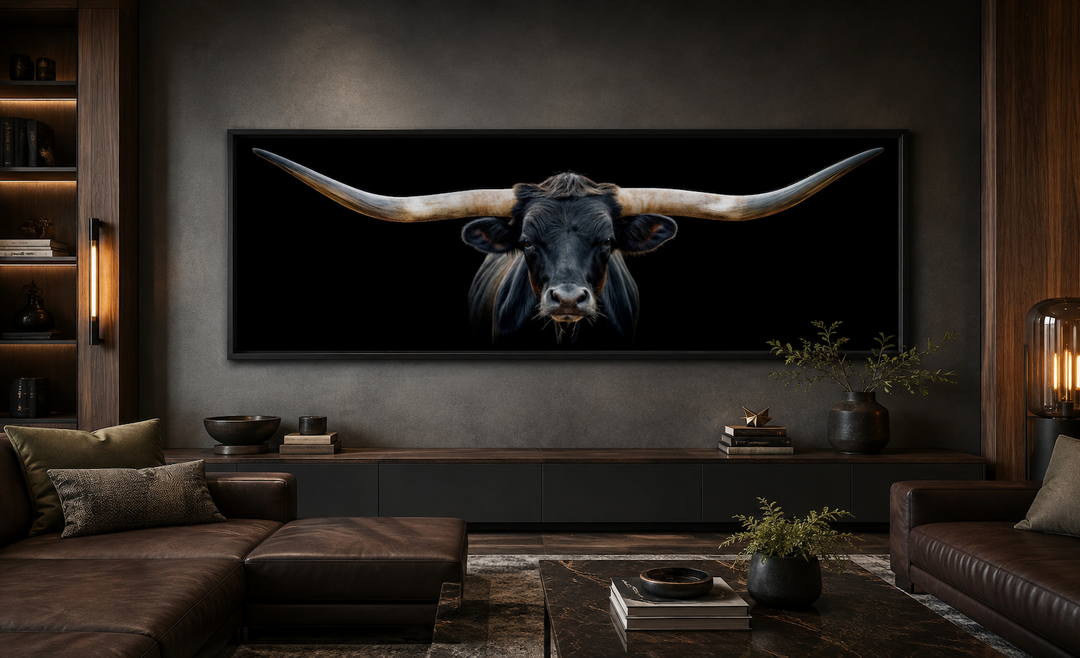 Panoramic framed canvas wall art of a black Texas longhorn steer hanging above a living room couch.