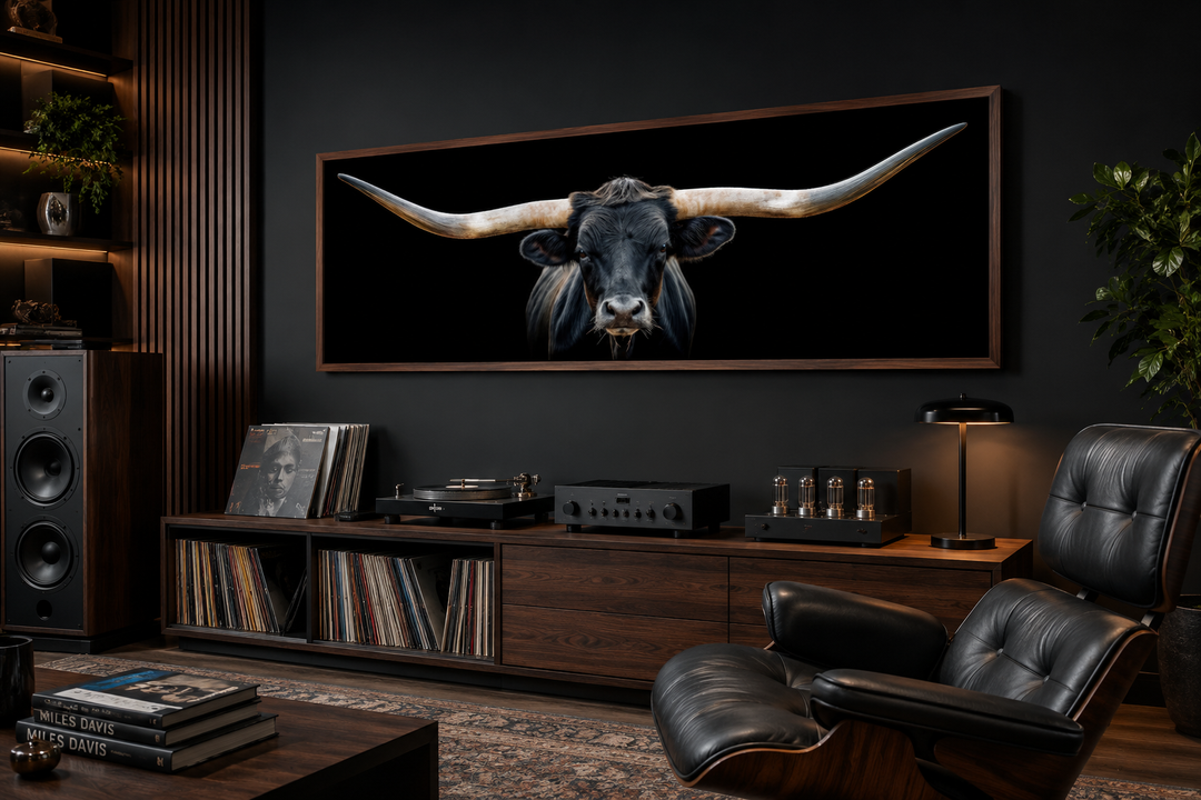 Panoramic framed canvas wall art of a black Texas longhorn steer above a dark wood media console.