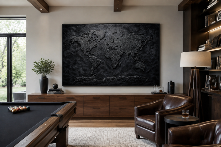 Large black textured world map framed canvas wall art in a modern man cave with a pool table.