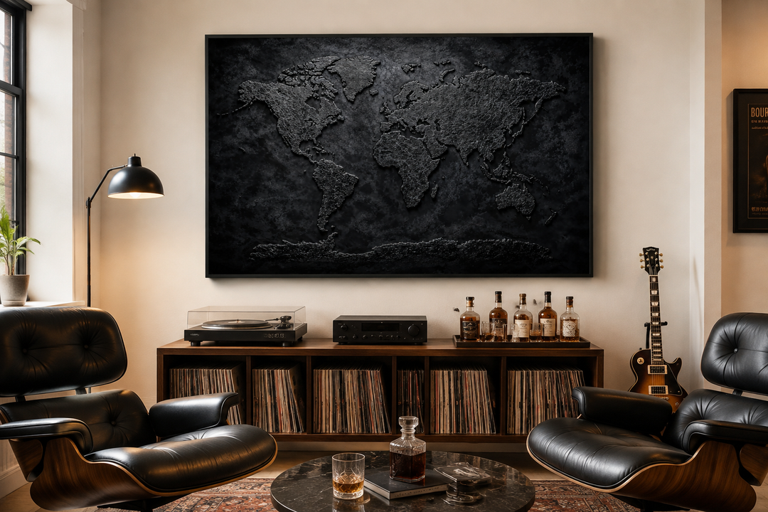 Black textured world map framed canvas wall art displayed in a modern office or man cave setting.