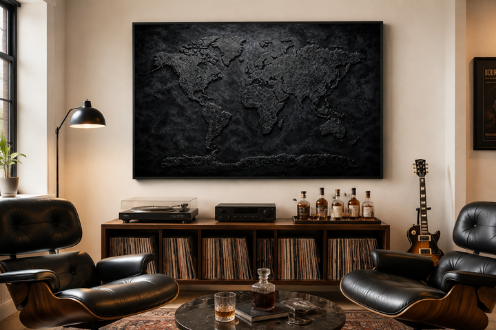 Black textured world map framed canvas wall art displayed in a modern office or man cave setting.
