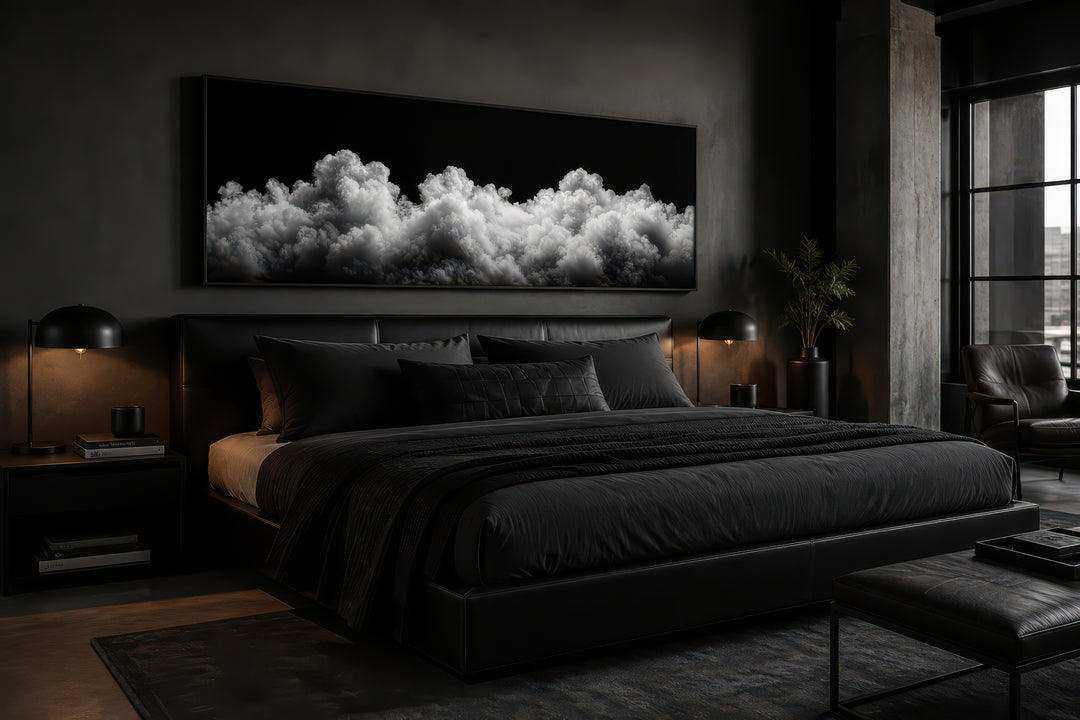 Black and white clouds long horizontal framed canvas wall art above a bed in a dark modern bedroom.