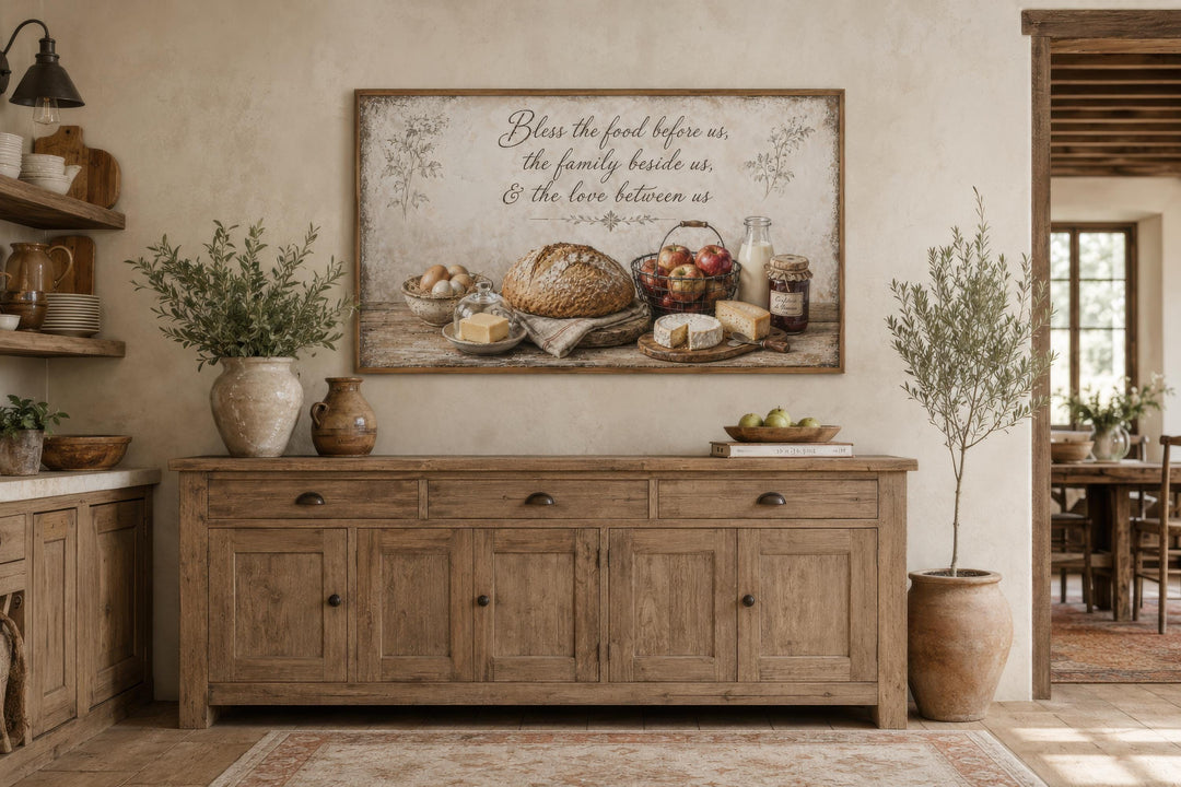 Rustic farmhouse canvas wall art with a food still life and a blessing above a wooden sideboard.