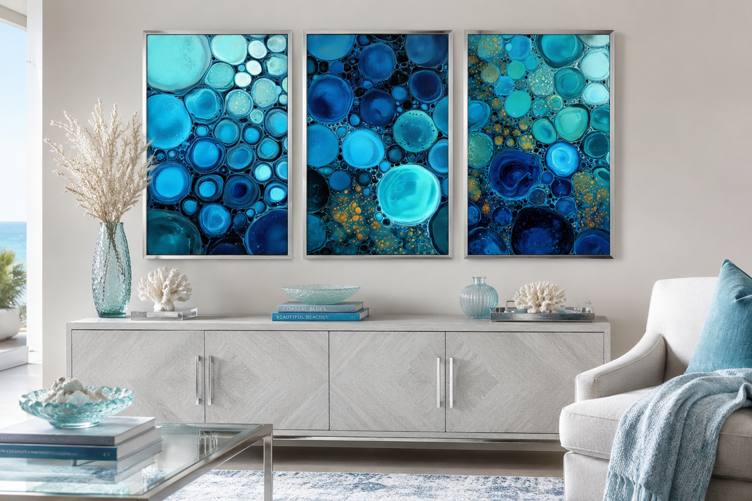 Set of 3 blue aqua and navy bubble abstract canvas prints displayed above a white console table.