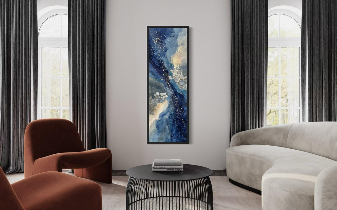 Tall narrow abstract canvas print featuring navy, beige, and gold tones in a black frame.