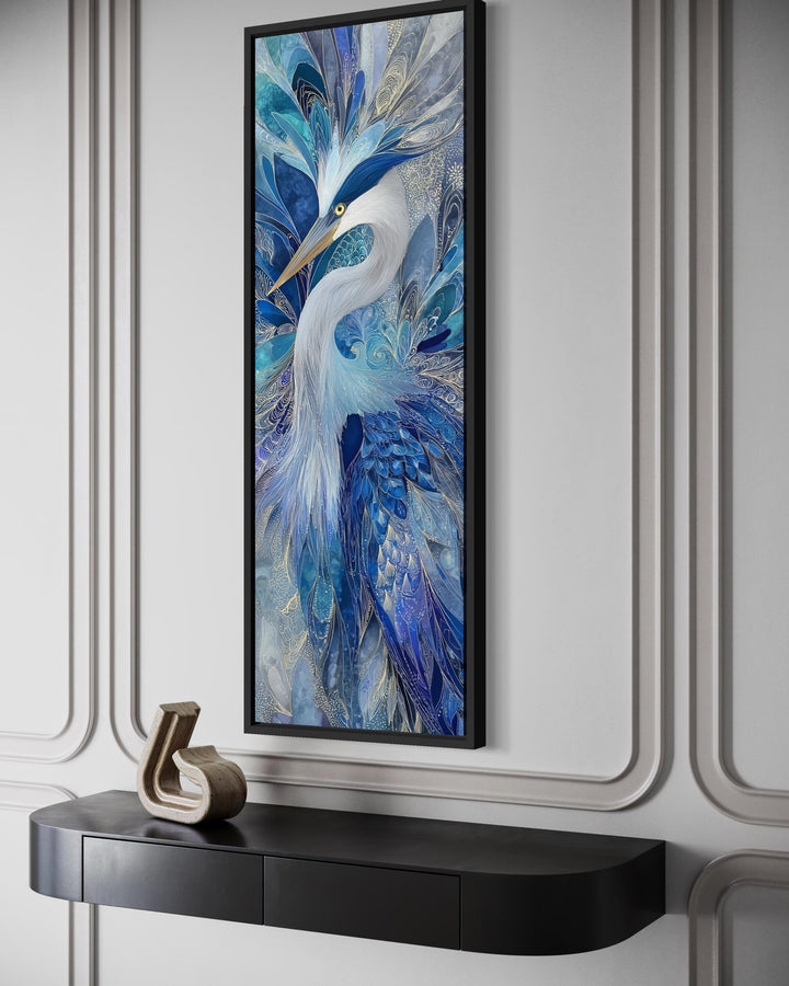 Vertical canvas print of an elegant heron in navy blue and sapphire tones on a paneled wall.