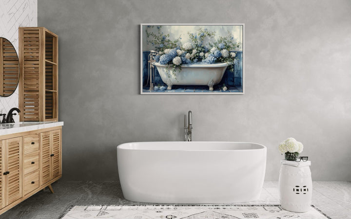 Horizontal canvas print of blue and white hydrangeas in a vintage clawfoot tub on a grey wall.
