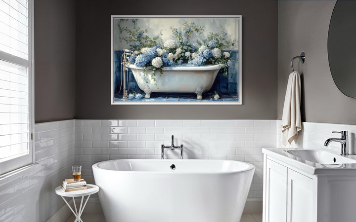 Blue and white hydrangea flowers in a vintage clawfoot tub canvas print on a dark bathroom wall.