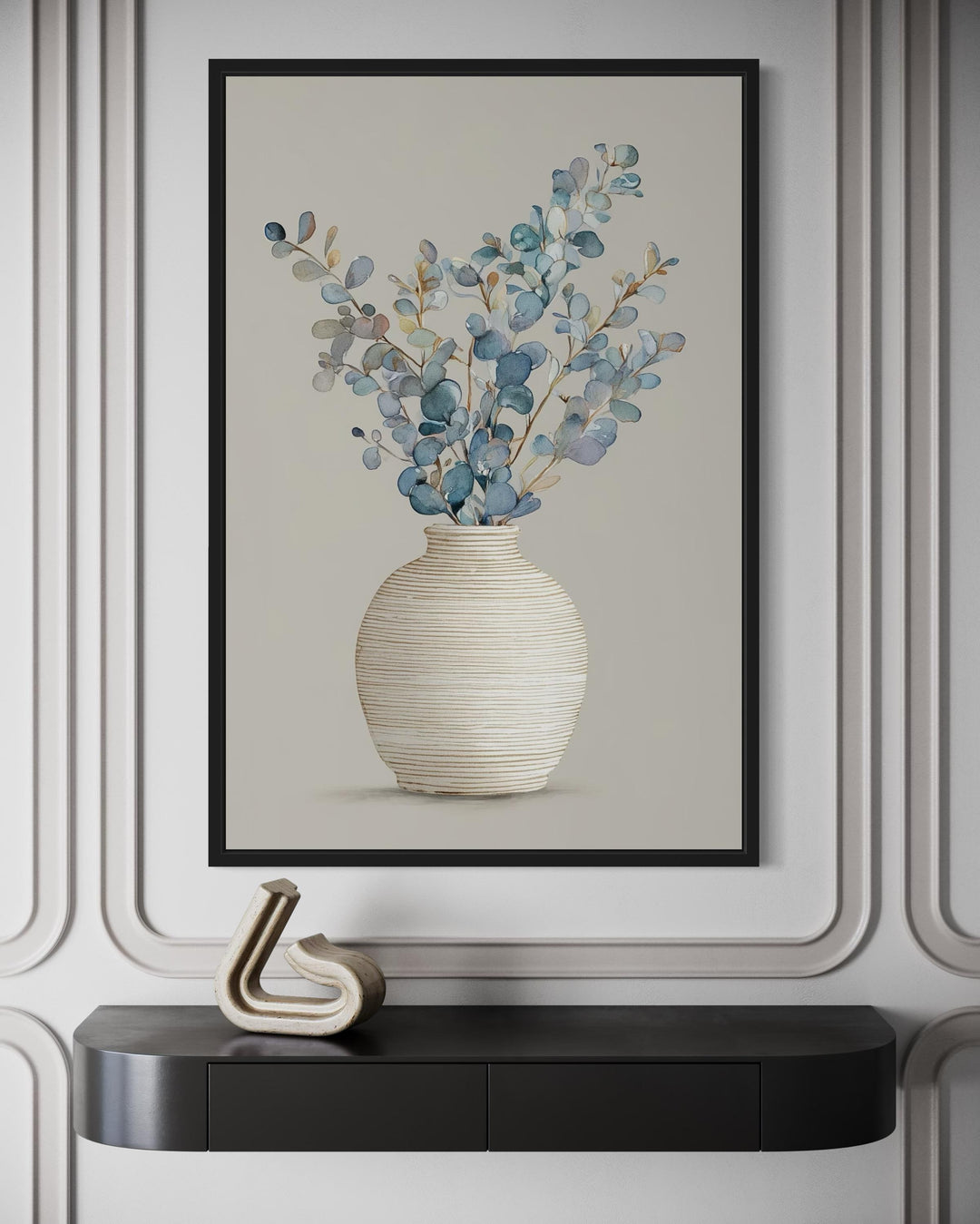 Blue floral still life wall art featuring eucalyptus branches in a textured vase on a cream wall.