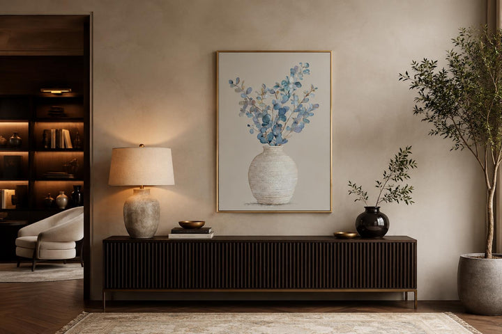 Blue floral still life wall art with eucalyptus branches in a textured vase and gold frame.