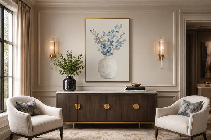 Blue floral still life wall art in a gold frame above a dark wood sideboard in a dining room.