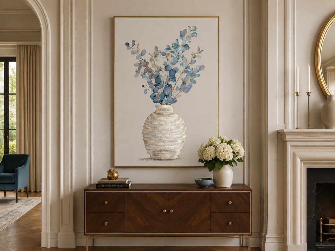 Blue floral still life wall art with eucalyptus branches in a textured vase and gold frame.