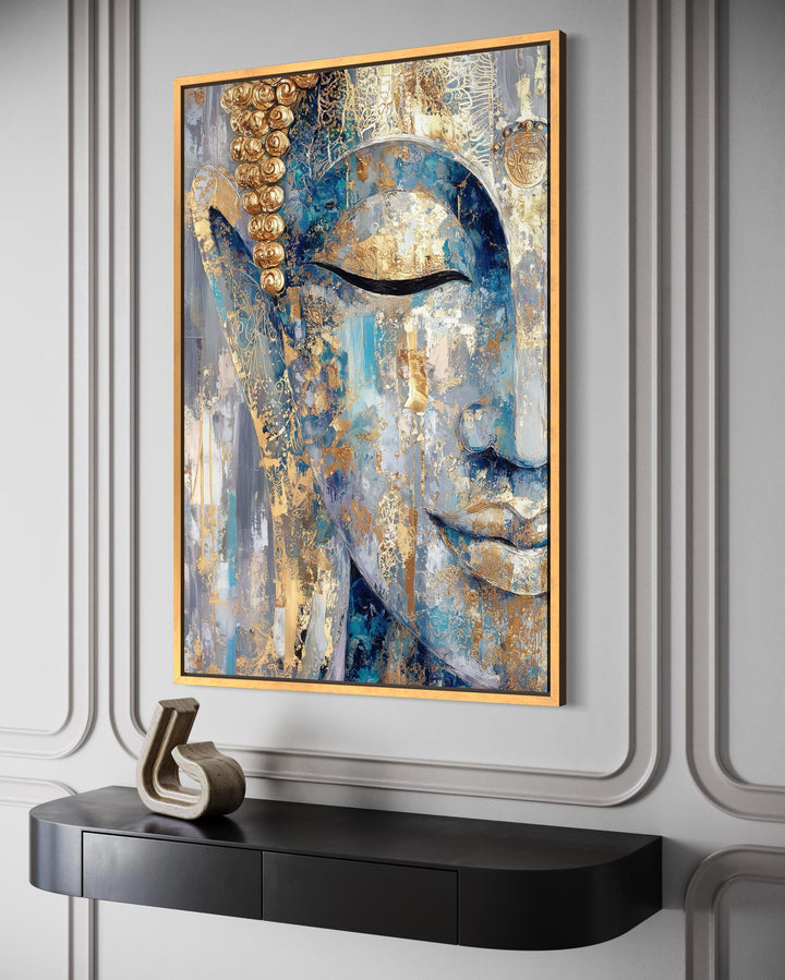 Blue and gold abstract Buddha canvas wall art in a gold frame above a black console table.