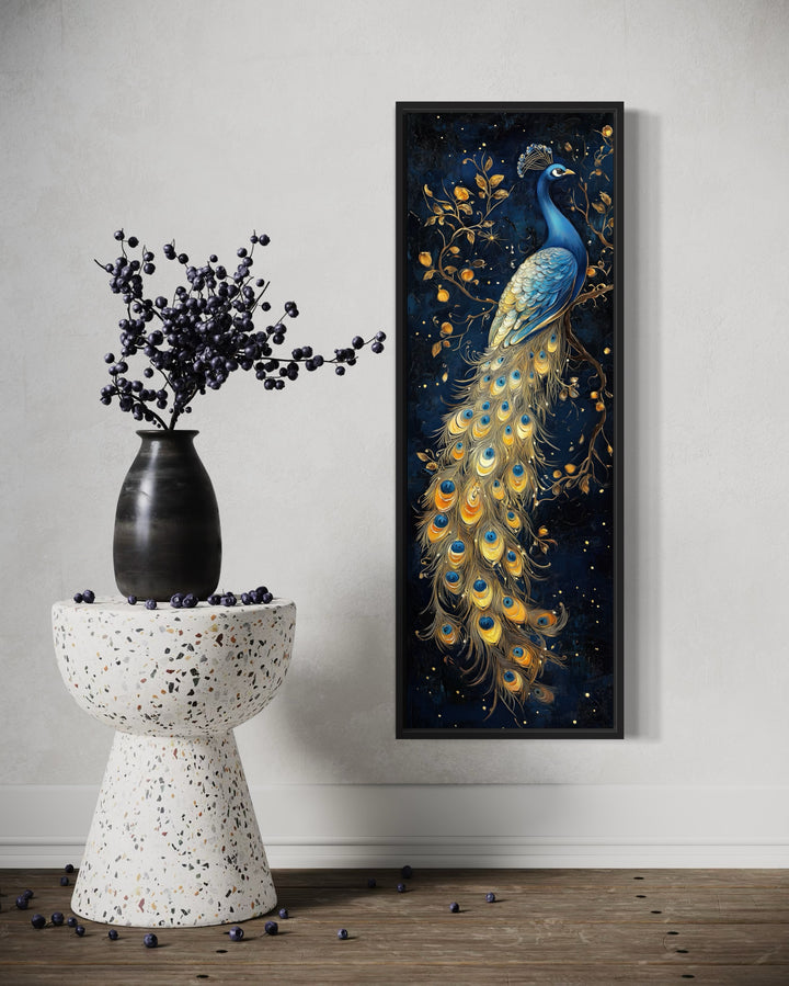 Tall narrow vertical framed canvas wall art featuring a blue and gold peacock on a navy background.