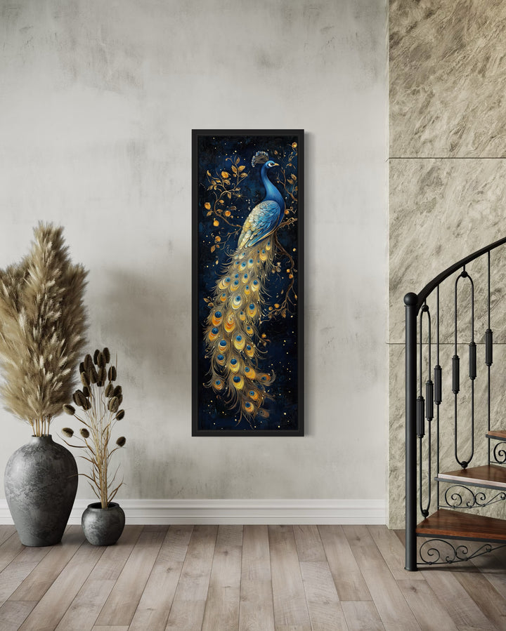 Tall narrow framed canvas wall art featuring a blue and gold peacock on a dark navy background.