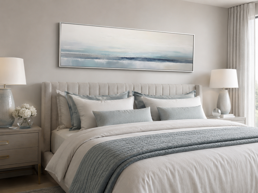 Blue gray calm coastal framed canvas wall art hanging over a bed in a modern bedroom.