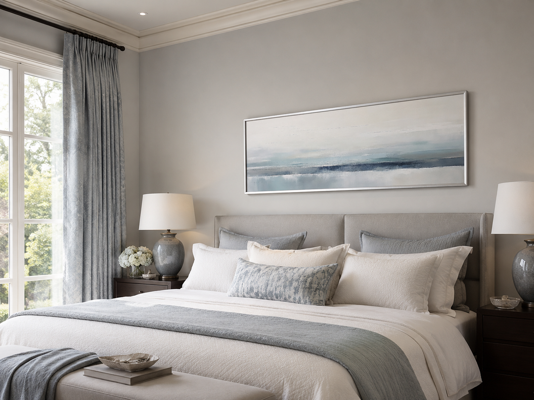 Blue gray calm coastal framed canvas wall art hanging over a bed in a serene bedroom.