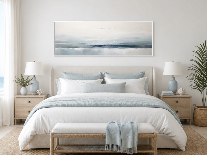 Blue gray calm coastal framed canvas wall art hanging above a bed in a serene bedroom.