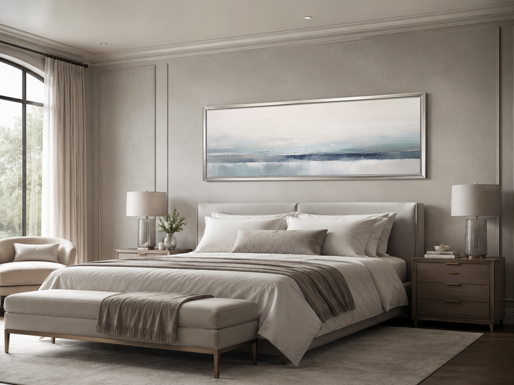 Blue gray calm coastal abstract landscape framed canvas wall art hanging over a bed.