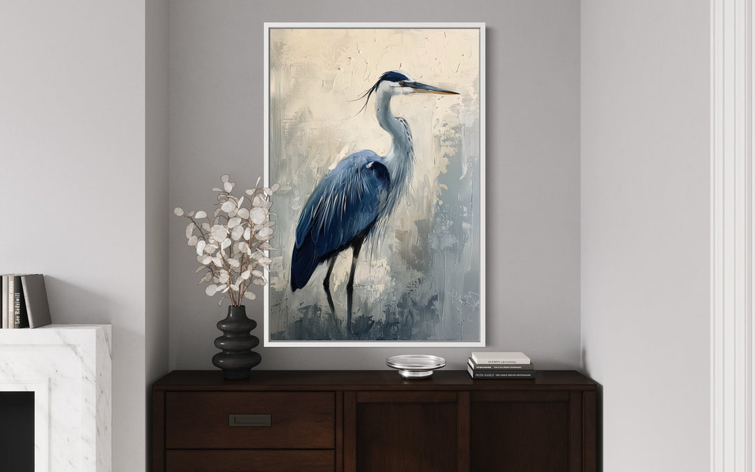 Blue heron abstract painting in a white frame, displayed on a wall above a dark wood sideboard.