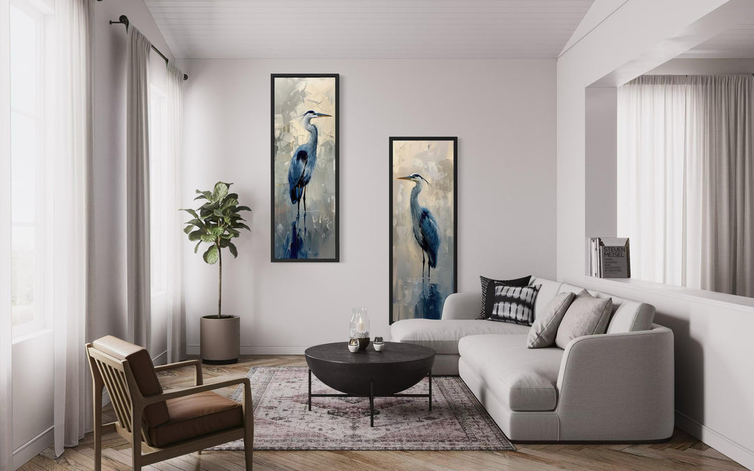 Set of two tall, narrow canvas wall art pieces featuring elegant blue herons in a modern room.