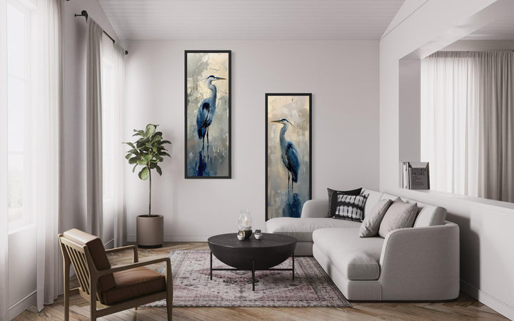 Set of two tall, narrow canvas wall art pieces featuring elegant blue herons in a modern room.