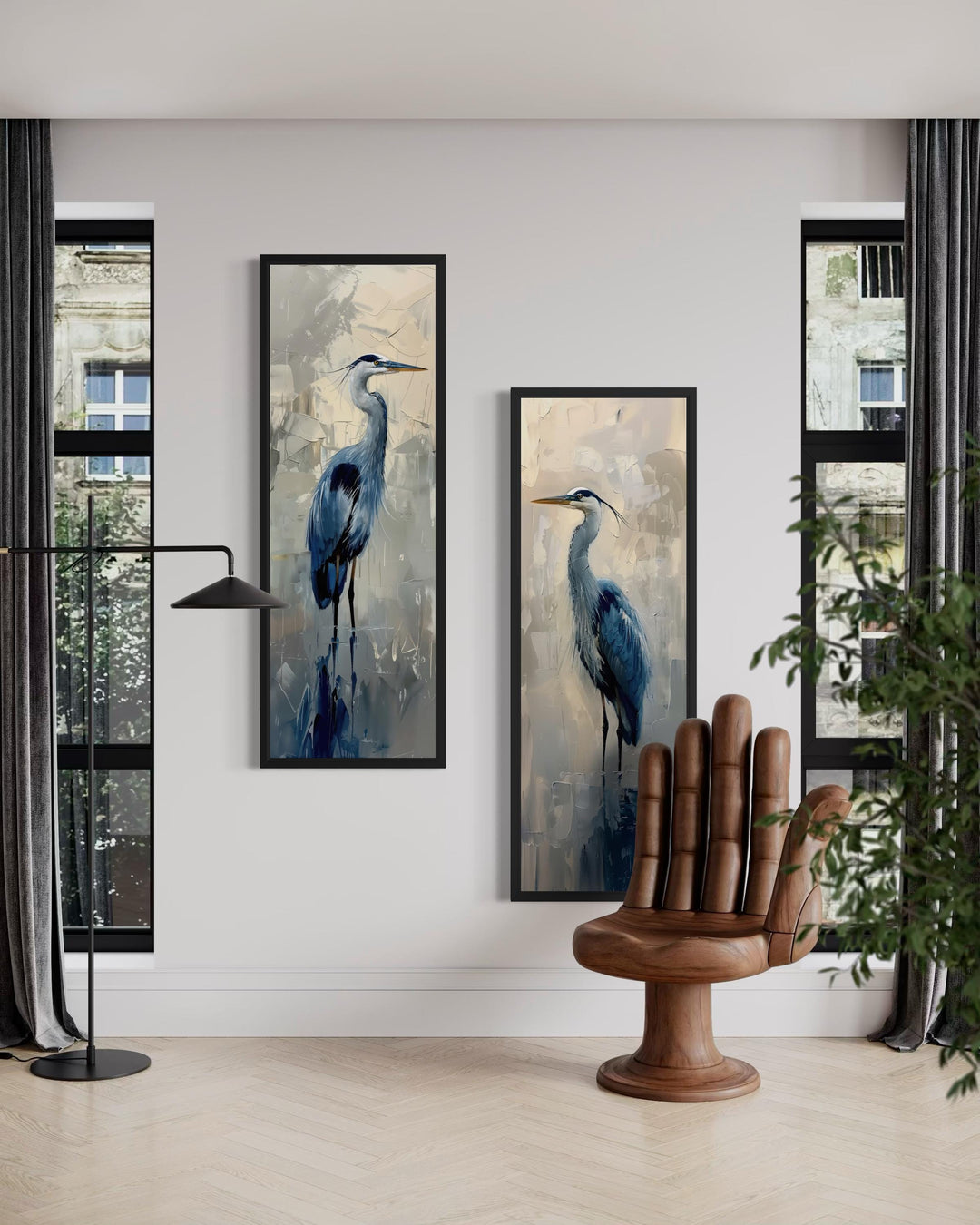 Two tall, narrow canvas prints of blue herons in a painterly style hang on a white wall.