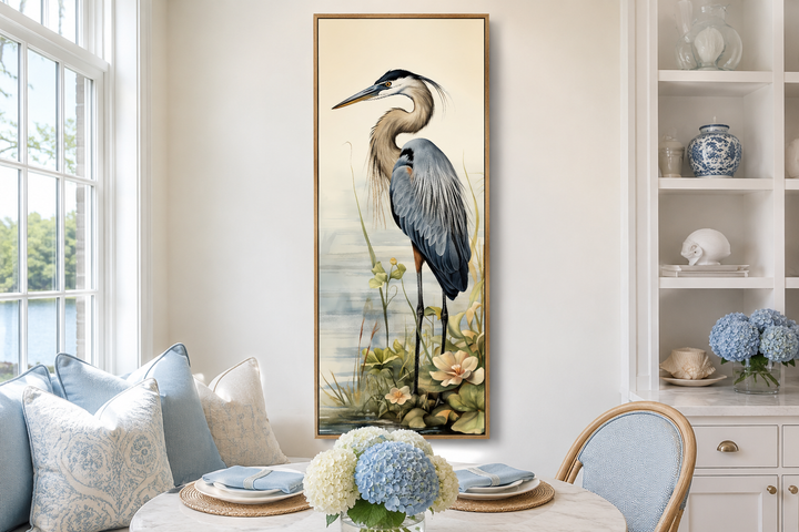 Tall narrow vertical framed canvas wall art featuring a detailed blue heron in a coastal setting.