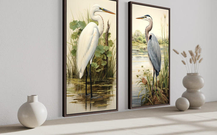 Two framed canvas prints featuring a white egret and a blue heron in lush wetland habitats.
