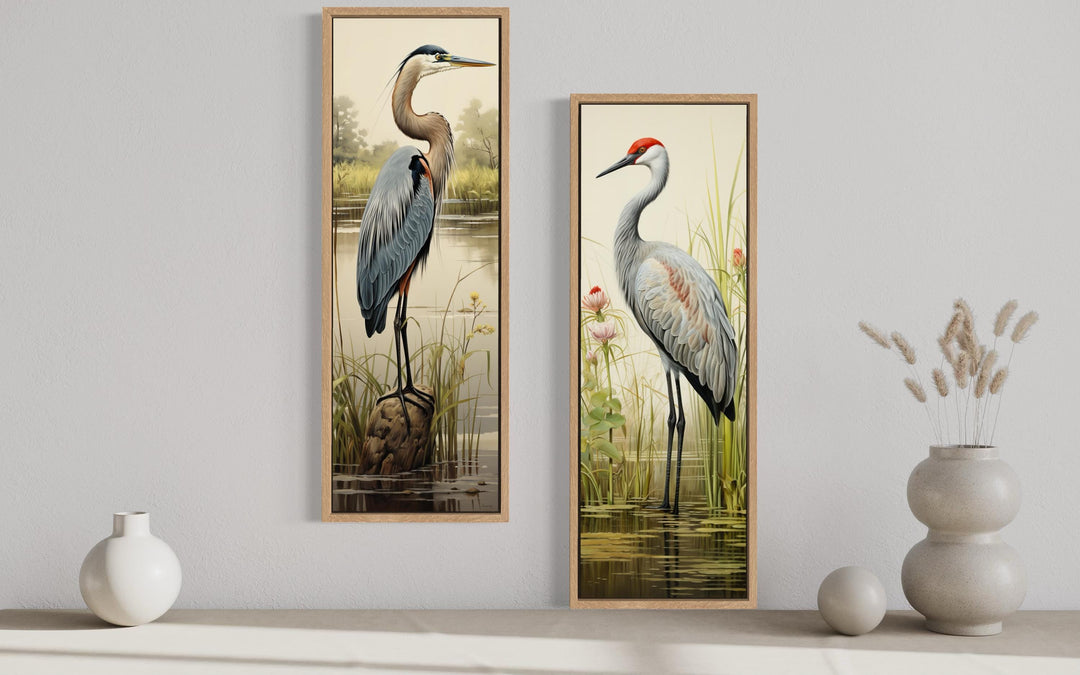 Set of two tall vertical canvas prints featuring a blue heron and a sandhill crane in marsh settings.