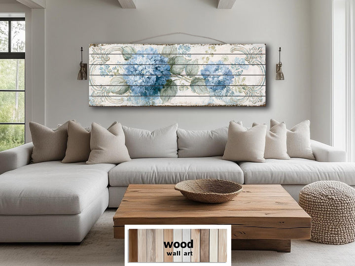 Blue hydrangea floral art printed on horizontal distressed wood planks above a neutral sofa.