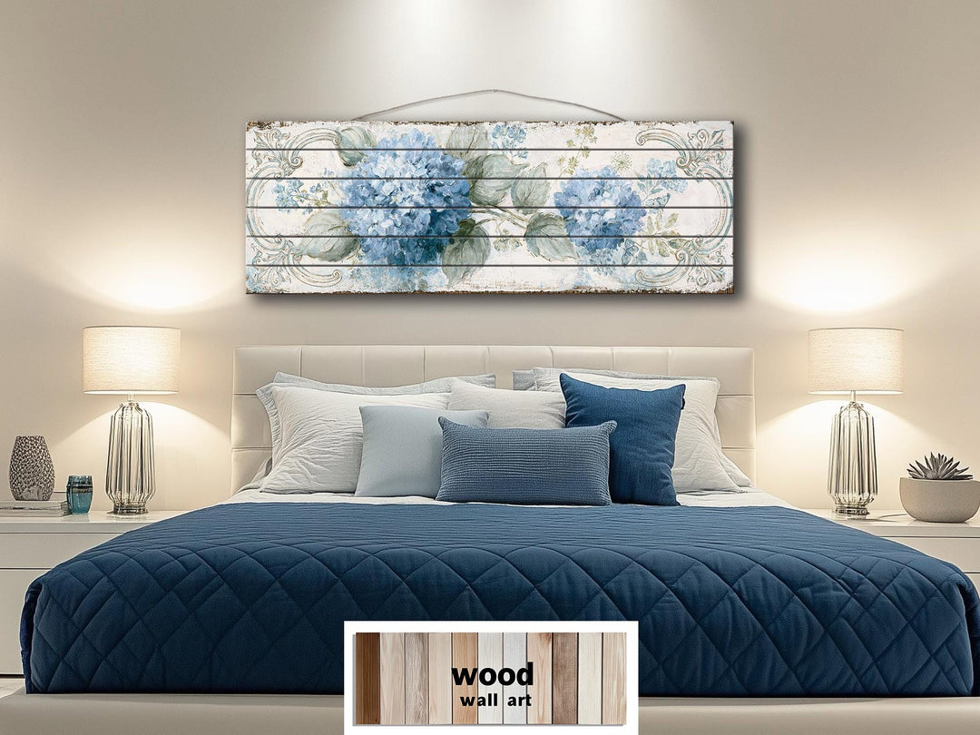 Blue hydrangea floral art on distressed wood planks displayed above a bed in a modern bedroom.