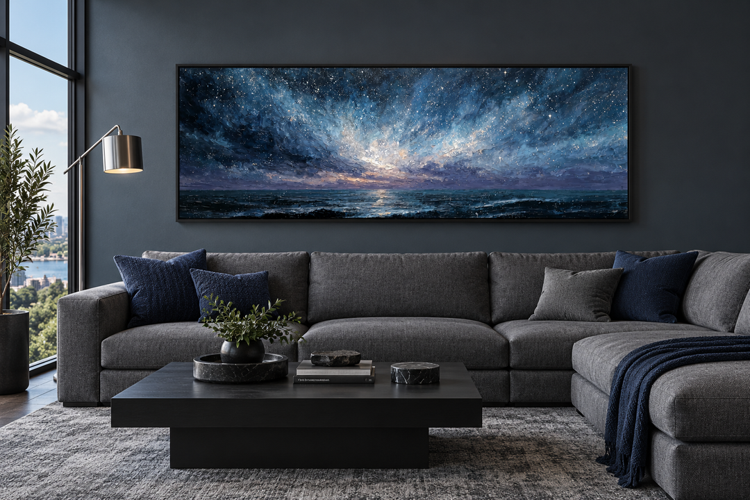 Wide panoramic navy and purple seascape painting above a grey sectional sofa in a modern room.