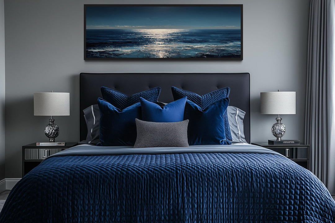 A long horizontal seascape wall art piece featuring a blue and silver ocean horizon above a bed.