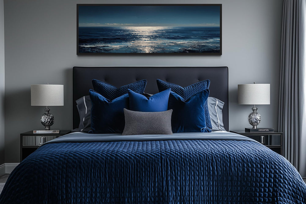 A long horizontal seascape wall art piece featuring a blue and silver ocean horizon above a bed.