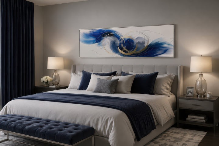 Blue, white, and gold minimalist abstract horizontal canvas art hanging above a bed.