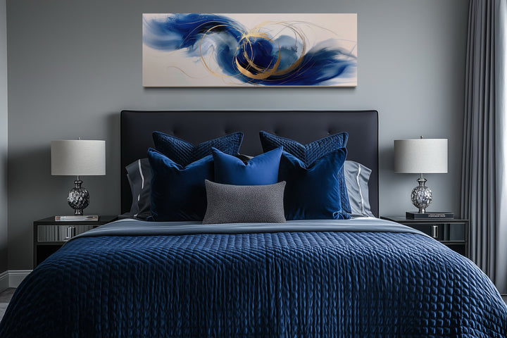 Blue, white, and gold minimalist abstract horizontal wall art hanging above a bed in a bedroom.