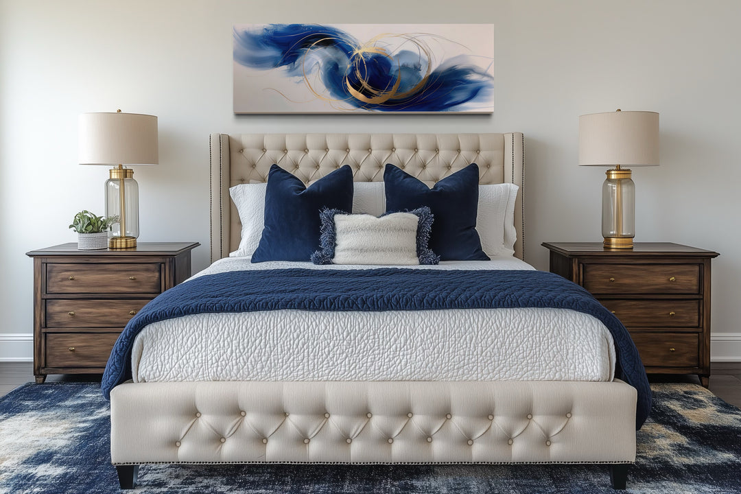 Blue, white, and gold minimalist abstract horizontal wall art hanging above a tufted bed.