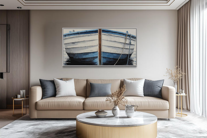 Blue and white rustic boat painting canvas wall art hanging above a beige sofa in a modern room.