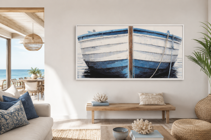 Blue and white rustic boat painting canvas wall art in a white frame above a wooden bench.