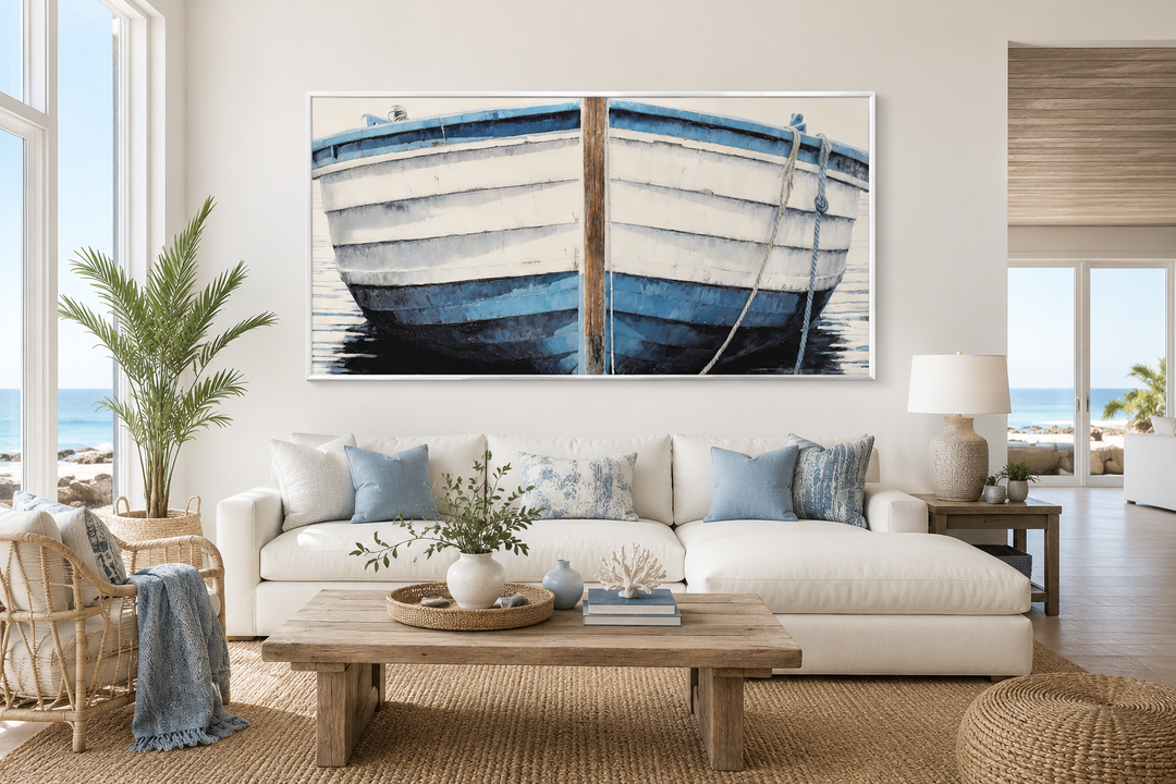 Large blue and white rustic boat painting canvas wall art above a white sofa in a coastal room.