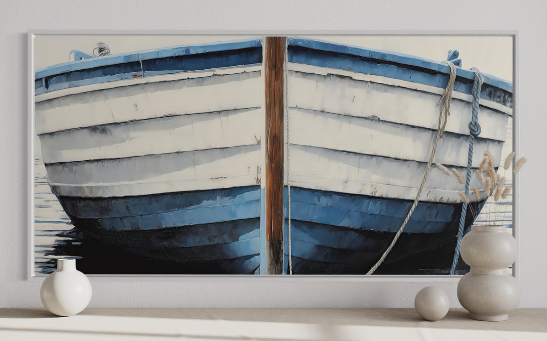 Blue and white rustic boat painting canvas wall art in a white frame above a shelf with vases.