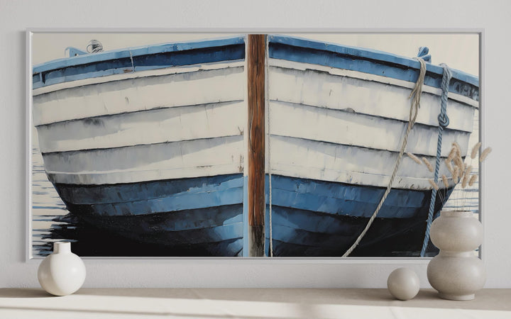 Blue and white rustic boat painting canvas wall art in a white frame above a shelf with vases.