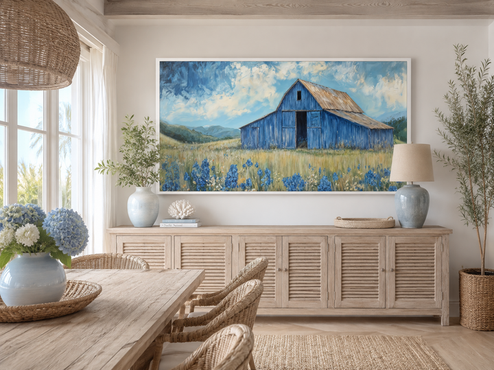 Blue barn and bluebonnets rustic framed canvas wall decor above a wooden sideboard in a dining room.