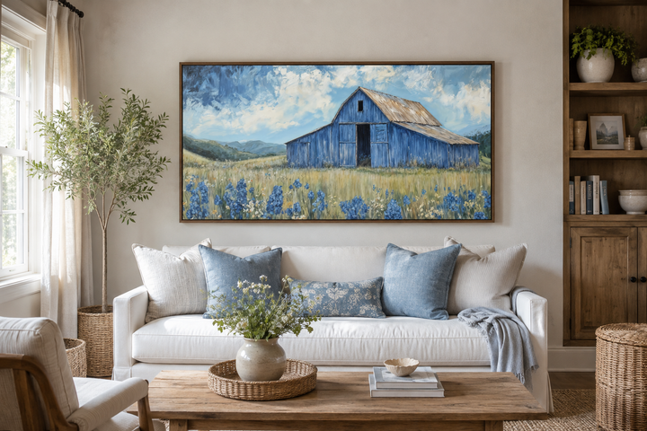 Blue Barn and Bluebonnets rustic framed canvas wall decor above a white sofa in a farmhouse living room.