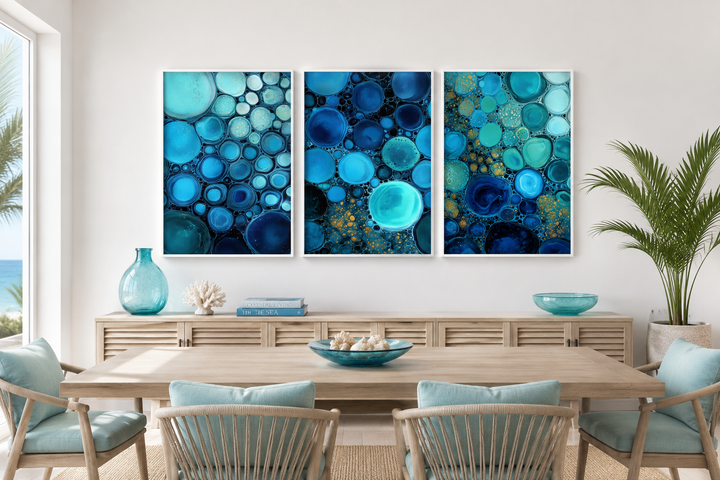 Set of three abstract canvas prints featuring blue, aqua, and navy bubble patterns on a white wall.