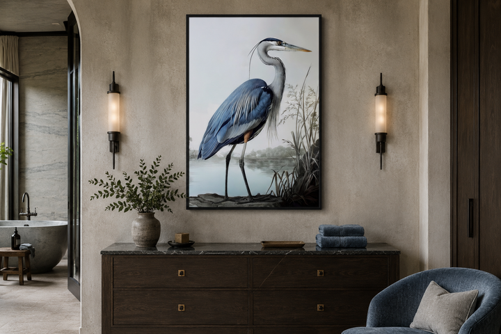Framed canvas wall art of a blue heron standing by a misty shoreline above a dark wood dresser.