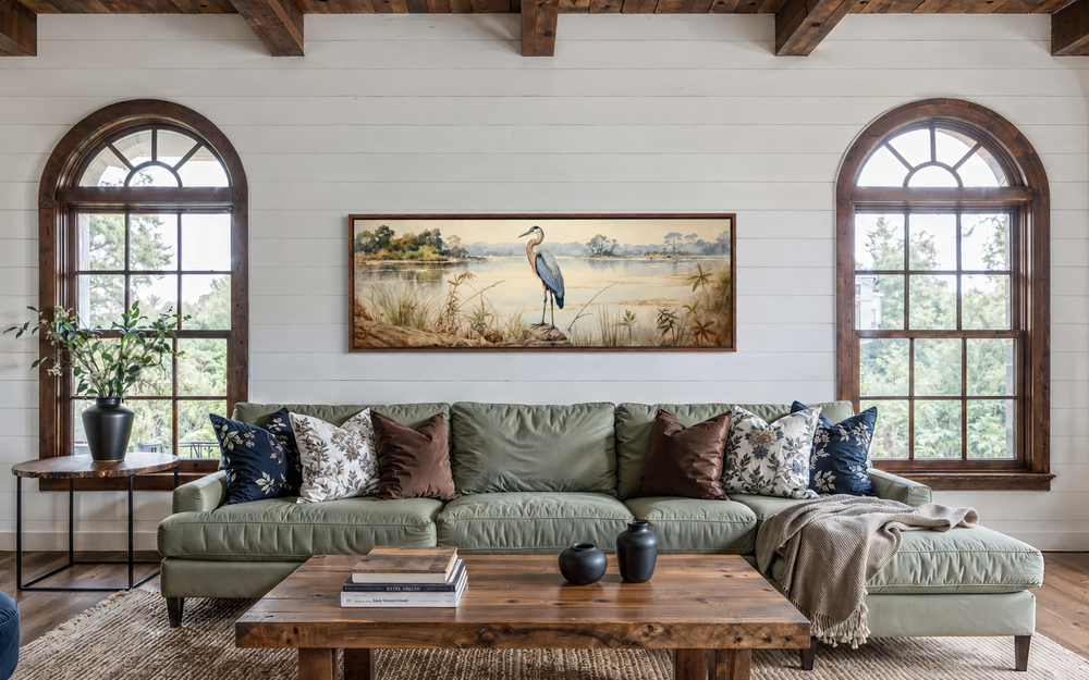 Blue Heron by the Lake long horizontal canvas wall art hanging above a green sofa in a living room.