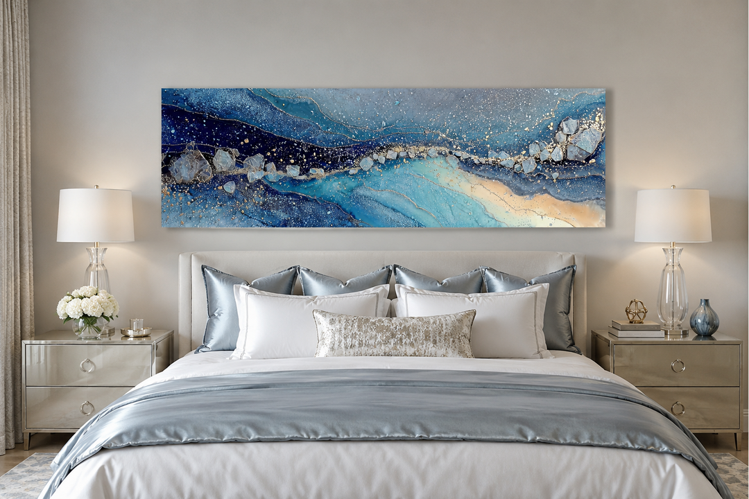 Modern long horizontal blue and navy abstract canvas art displayed above a bed in a bedroom.