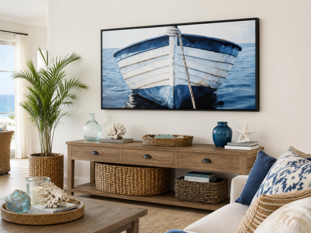 Framed canvas print of a rustic blue and white boat hanging above a wooden console table.
